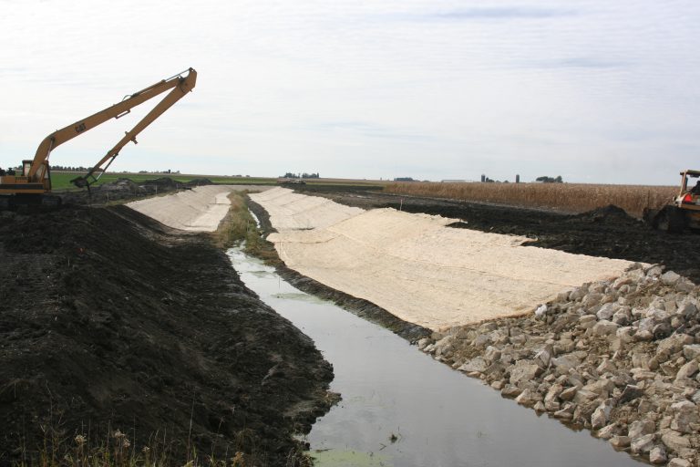 Heavy machinery digs a trench for a stream