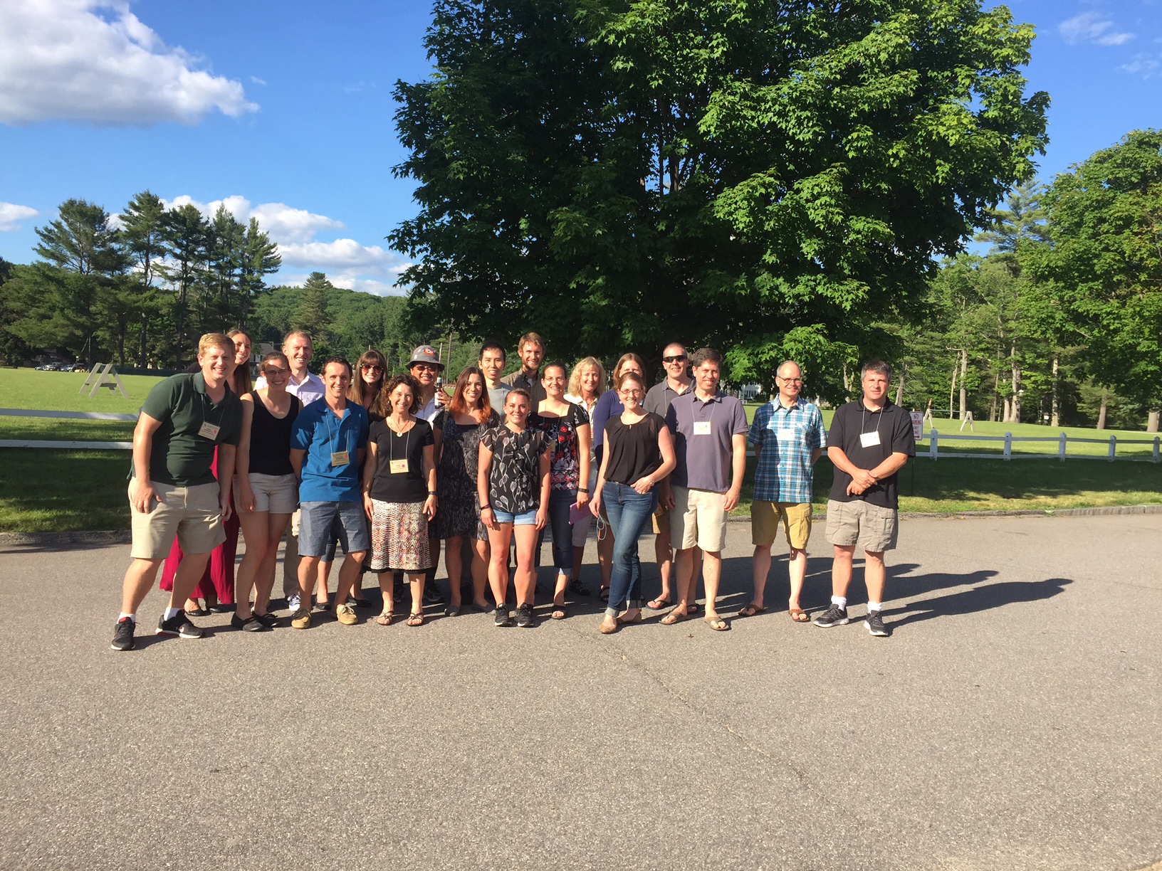A group of people stand together in a sunlit area 