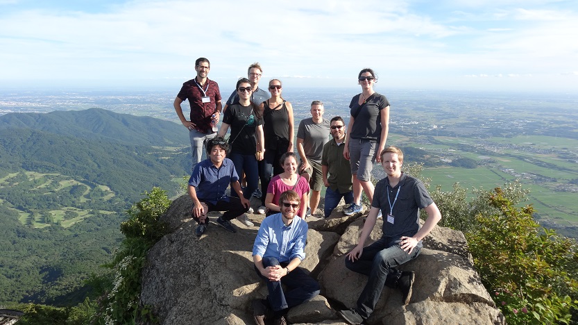 Greg and others at the NAE conference on a rock with a valley behind them